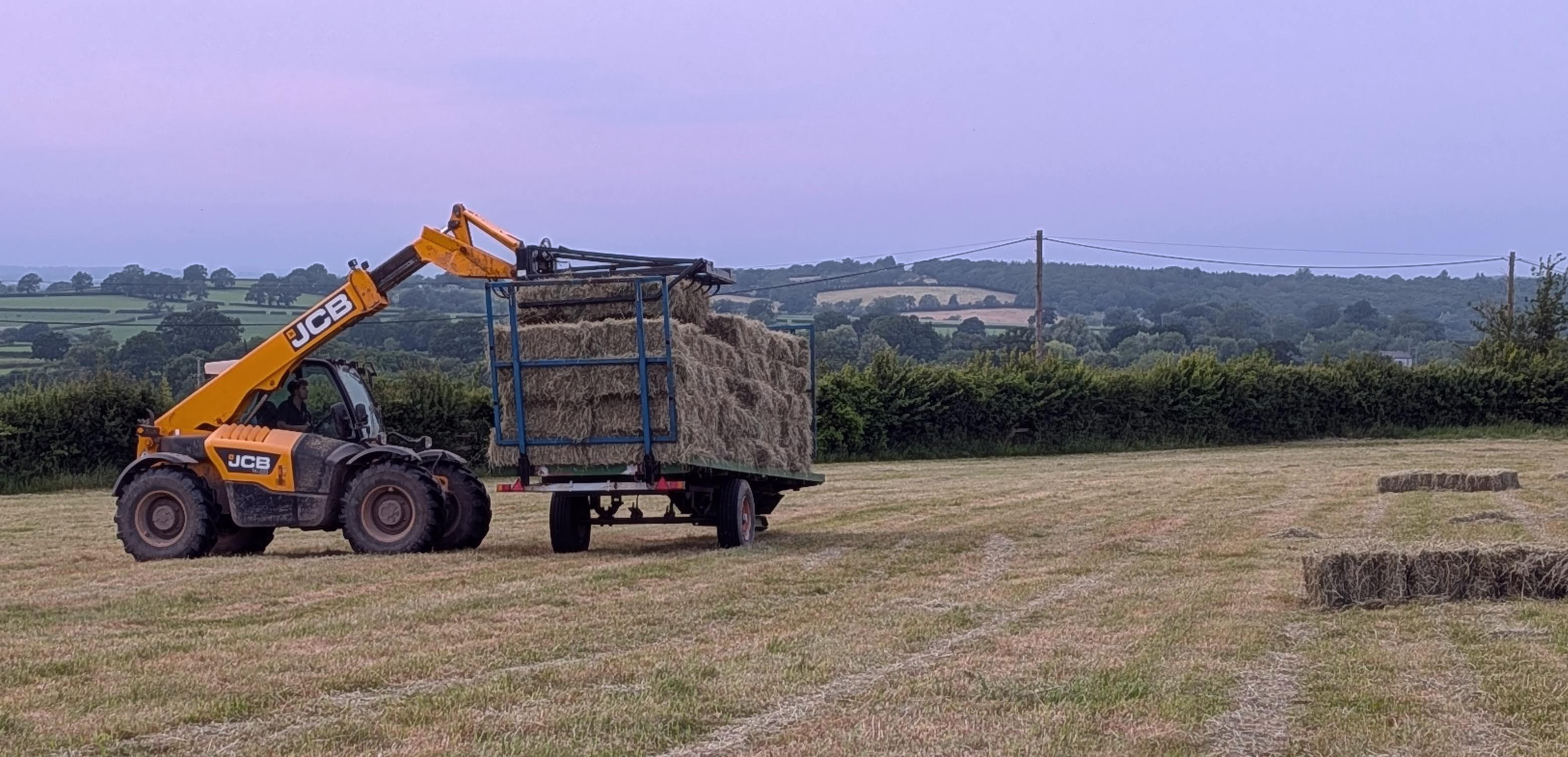 collecting hay bales in a field